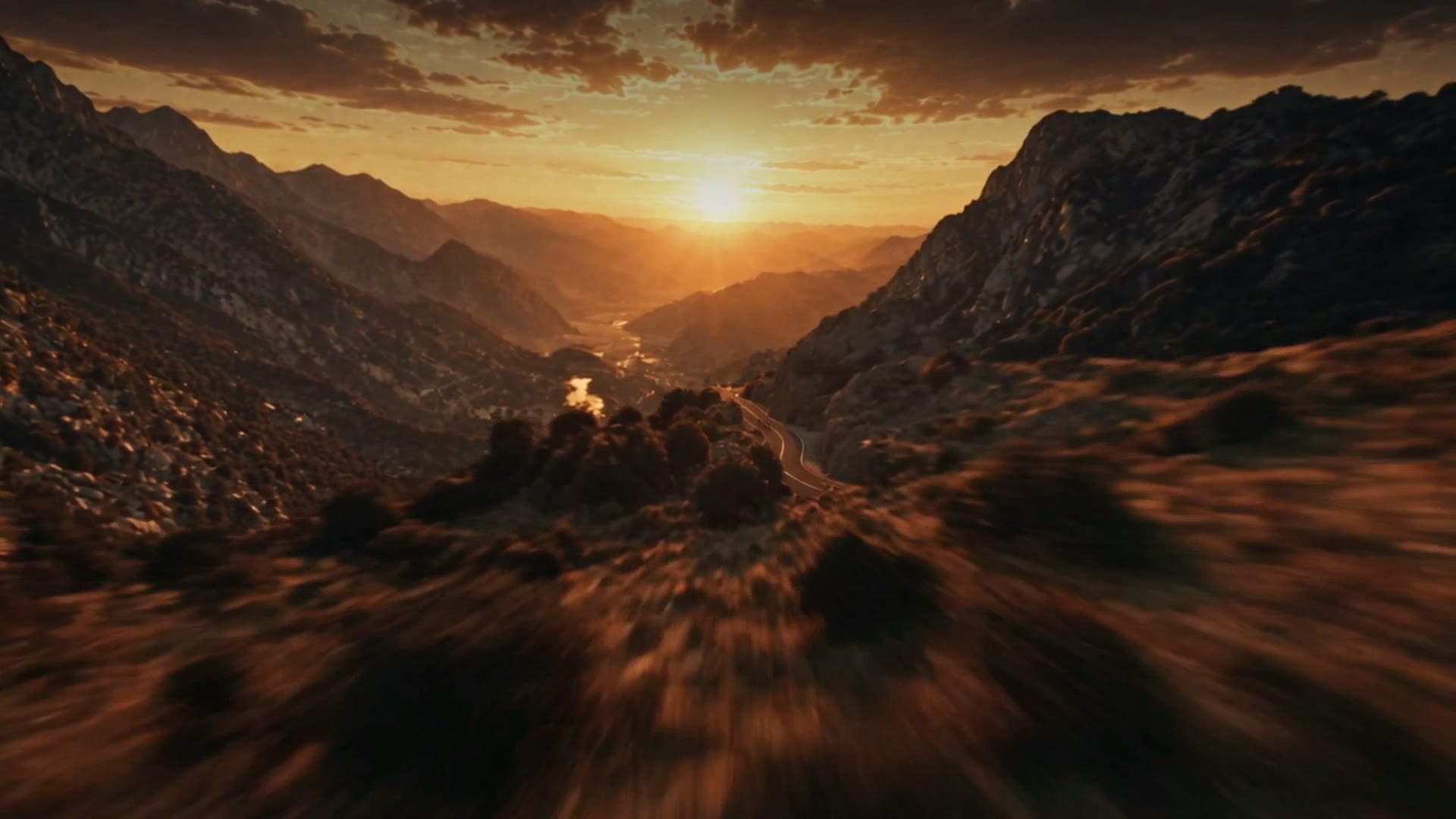 La camera vola bassa su una valle al tramonto, verso una strada di montagna