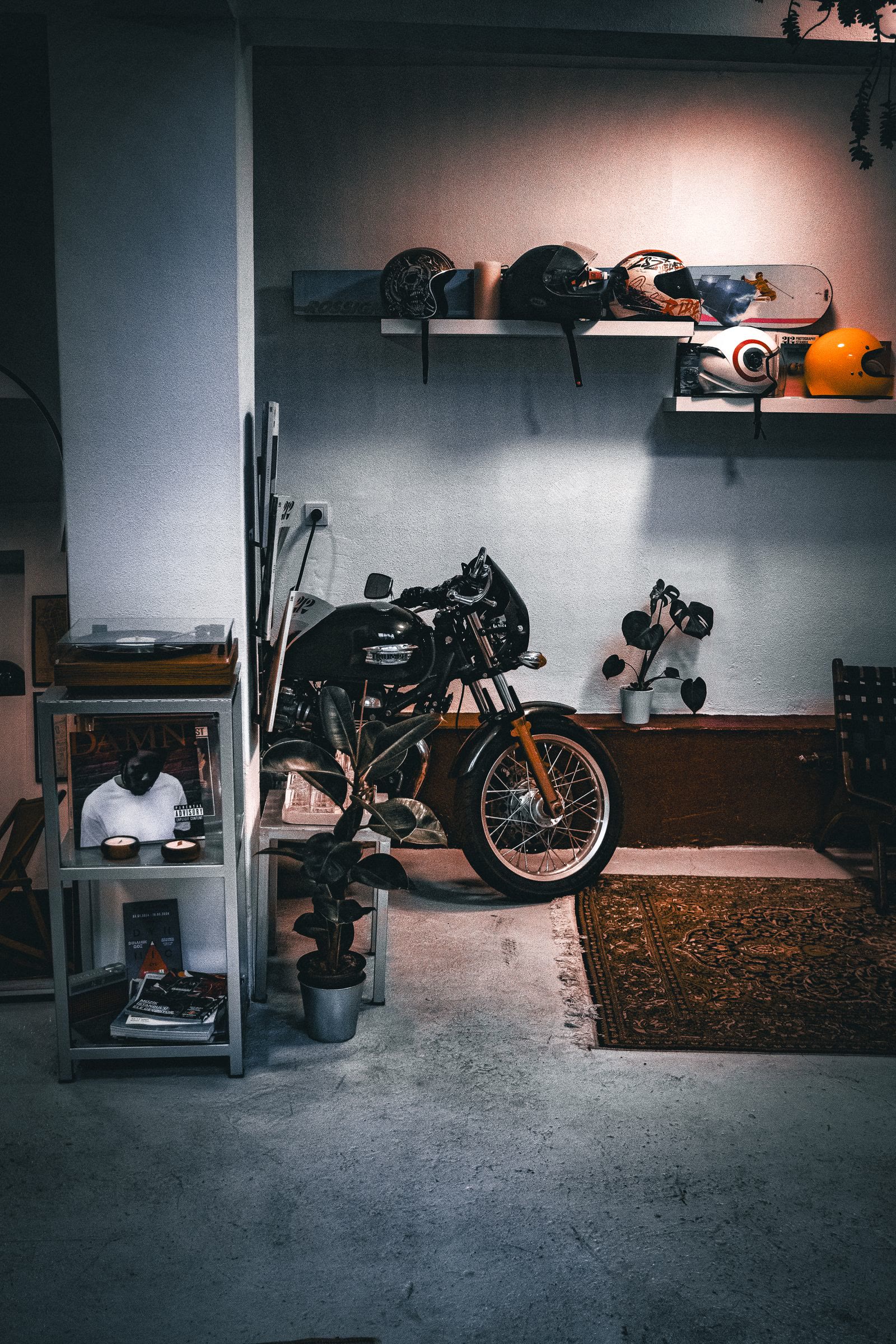Una moto esposta in un interno con caschi e accessori sugli scaffali
